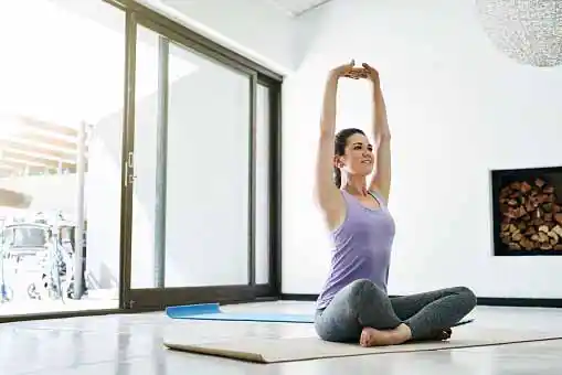  woman doing yoga in room=